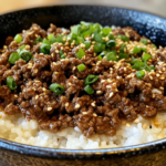 A delicious Korean Ground Beef Bowl served over white rice, topped with fresh green onions and sesame seeds.